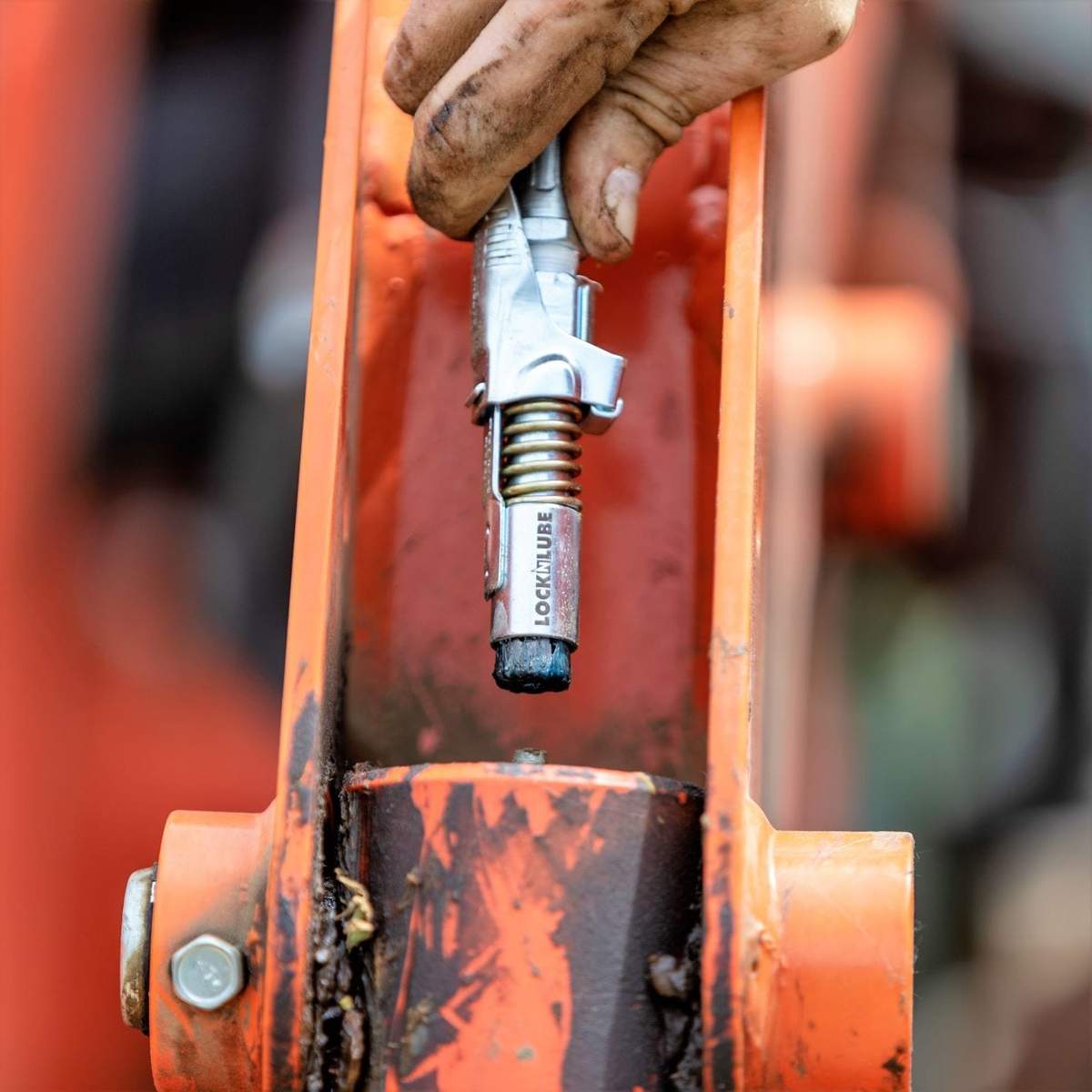 LockNLube Grease Coupler locked onto a Zerk fitting on a Kubota machine
